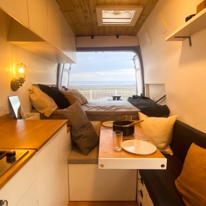 imagem mostrando o interior decorado de uma campervan com paisagem ao fundo